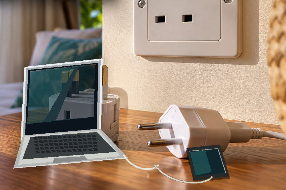 Telefon i laptop ładowane przez adapter w hotelowym pokoju